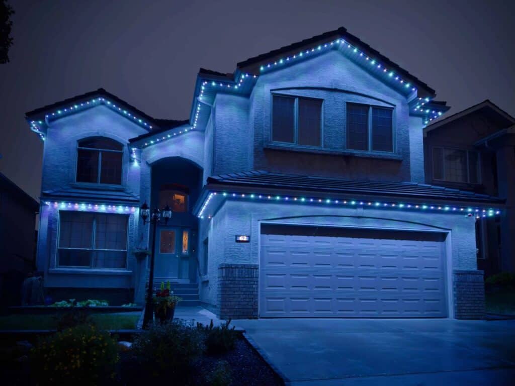 Home with cool white permanent LED roofline lighting at night