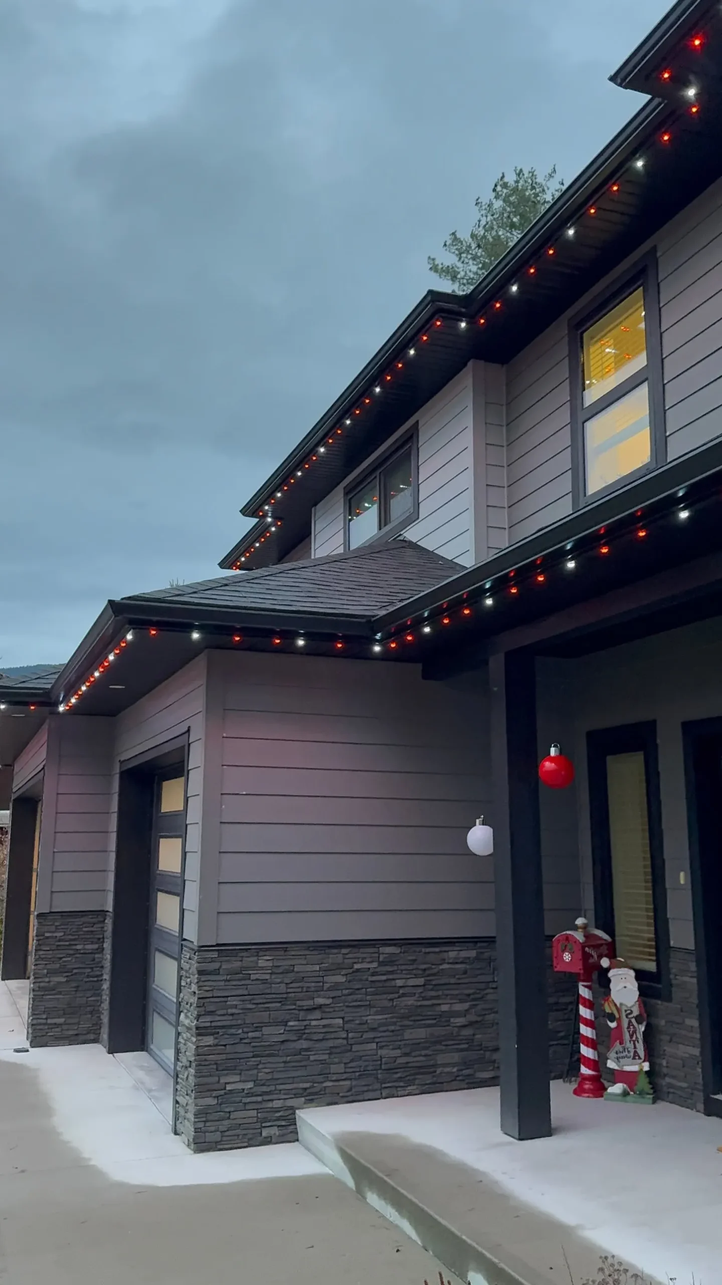 Red and warm white permanent LED lights installed by Grit & Grind on a Castlegar home